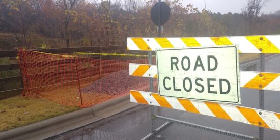 The sinkhole, filled with gravel, is behind and to the left of the barricade | 2018 file photo
